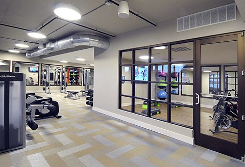 a gym with a lot of equipment and windows